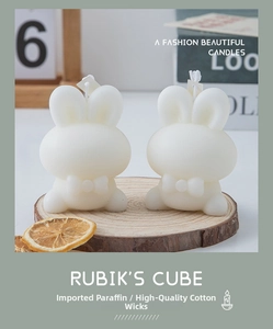 Detail of cute white rabbit candles with cotton wick on a rustic wood slice base