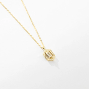 Detailed close-up of a hexagonal gold necklace pendant featuring a rectangular zircon stone