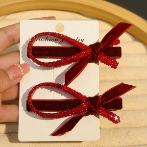 Set of two luxury red velvet bow hair clips with rhinestones on a white jewelry card