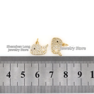 Macro detail of gold-plated whale pendants with micro-pave zircons for DIY jewelry