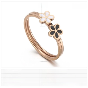 Détails de la bague fleur en or rose avec charmes en résine noire et blanche et mesures