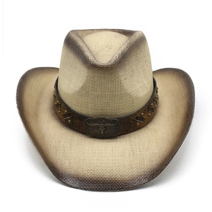 Détail d'un chapeau de cowboy en paille avec bande en cuir riveté et boucle de taureau