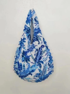 Detailed close-up of blue and white floral paisley textured magic stretch bubble bag fabric