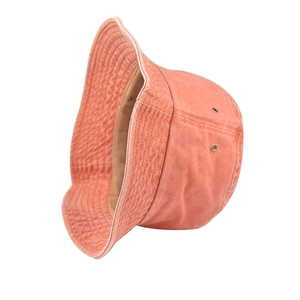 Dettaglio del cappello a secchiello in cotone corallo con cuciture e occhielli in metallo