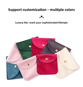 Close-up of colorful velvet jewelry pouches with gold snap buttons in multiple shades