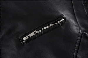Detailed close-up of a black leather jacket featuring a silver metal zipper and stitching
