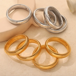 Minimalist gold and silver tone tubogas stretch bracelets on natural stone display
