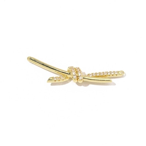 Detailed macro view of golden knot jewelry connector set with sparkling zircon stones