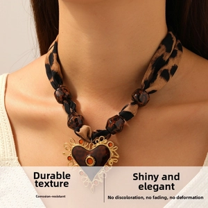 Détail du collier ruban léopard avec pendentif cœur et perles en résine au cou