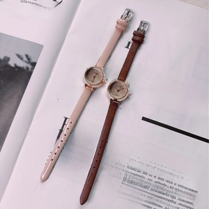 Close-up of pink and brown leather vintage quartz watches on a lifestyle magazine