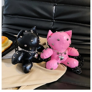 Detail of doll crossbody bags with metallic studs and heart pendant chain straps
