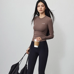 Close-up of slim-fit brown yoga top with breathable long sleeves and crew neck design