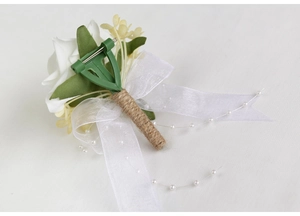 Détail du dos de la boutonnière de mariage en rose blanche avec épingle et ficelle