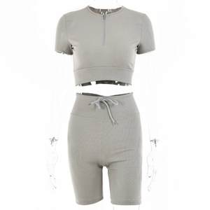 Detailed close-up of grey ribbed two-piece set featuring half-zip crop top and drawstring shorts