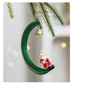 Detail of Santa Claus on a green crescent moon ornament with gold bell on a pine branch
