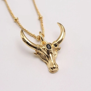 Gold plated bull head necklace with black gemstone and beaded chain in minimalist style