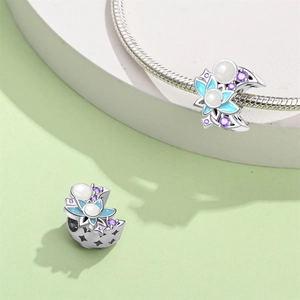 Detail of floral charm with blue enamel petals and purple crystal for DIY bracelets