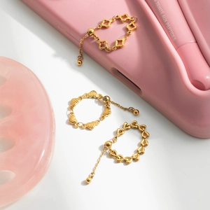 Detail of adjustable 18K gold plated stainless steel heart and clover chain rings