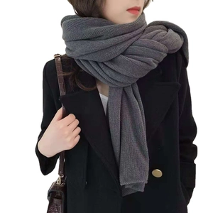 Classic grey knitted winter scarf for men and women worn with a black wool coat