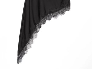 Close-up of black satin fabric with intricate lace detailing on the asymmetrical top