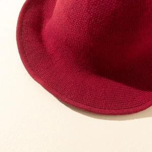 Macro detail of high-density red knitted fabric and crochet texture on a witch hat