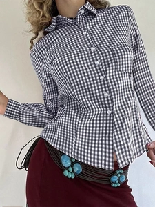 Detail of Y2K black and white plaid button-up shirt with turquoise belt and burgundy skirt