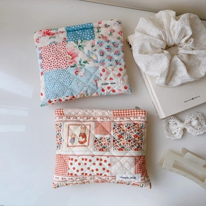 Gros plan détaillé de trousses à maquillage matelassées à fleurs avec motifs de lapin