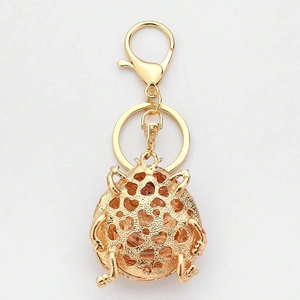Close-up of golden ladybug keychain with intricate heart-shaped hollow-out metal design