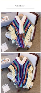 Detail of colorful geometric knit shawl with faux fur collar and vibrant tassels