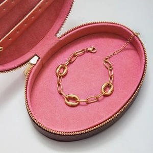 Détail d'un bracelet en acier inoxydable doré 18K dans son écrin en velours rose