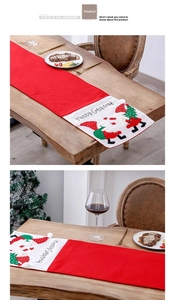 Detail of red Christmas table runner with Merry Christmas embroidery and gnome pattern