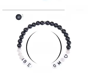 Macro detail of 6mm frosted bead bracelet featuring Mom letter beads and elastic band