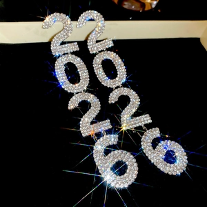 Macro shot of sparkling crystal 2026 number earrings with rhinestone fringe details