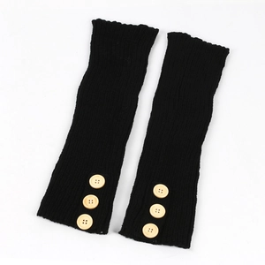 Detail of black ribbed knit leg warmers with vintage style wooden buttons on white background