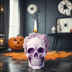 Lavender skull candle with rose crown detail burning in a spooky Halloween setting