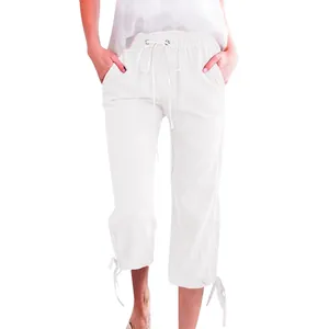 Detailed view of elastic drawstring waist and bow-tie cuffs on white linen pants