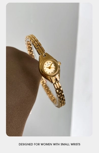 Détail de la montre GEDI dorée avec cadran minimaliste sur fond de soie élégant