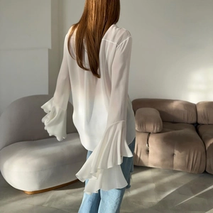 Detailed view of layered ruffle bell sleeves on a white chiffon blouse for women