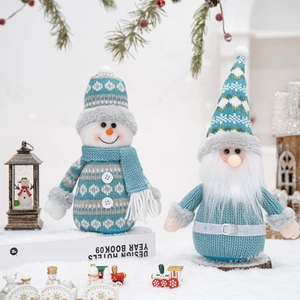 Detail shot of blue knitted snowman and Santa figurines on snowy background for holiday decor