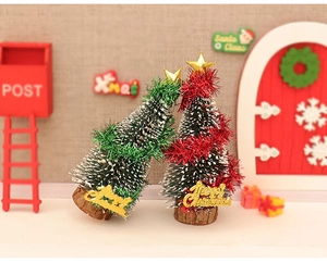 Close-up of mini Christmas trees with red and green ribbons on wooden bases