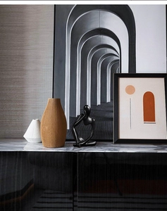 Close-up of a modern black abstract thinker sculpture on a luxury marble console table