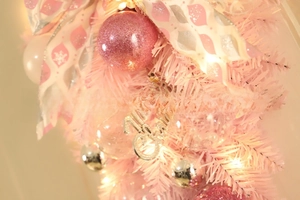 Detail of pink Christmas teardrop swag with LED lights, silver baubles and festive ribbons