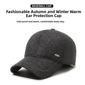Detail of dark grey winter baseball cap with earmuffs and metallic decorative logo