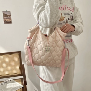 Sac à bandoulière matelassé rose avec fleurs et lapins porté par un mannequin