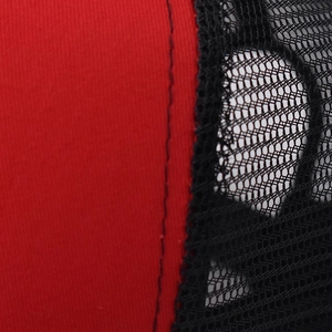 Macro detail of breathable black mesh and red cotton fabric stitching on baseball cap