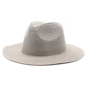 Dettaglio del cappello di paglia beige finemente intrecciato con corona in stile jazz