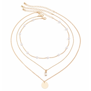Detail of gold layered necklace featuring imitation pearls and a rectangular zircon pendant