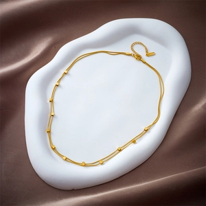 Minimalist double-layered gold stainless steel necklace with small square beads on silk