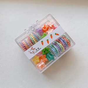 Macro detail of colorful kids hair clips and spiral bands in a clear square organizer box
