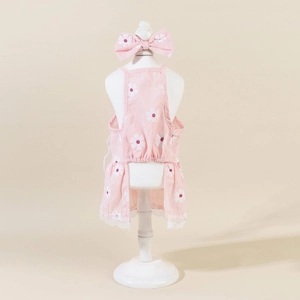 Pink floral pet sundress with daisy pattern and white lace trim on a small model stand